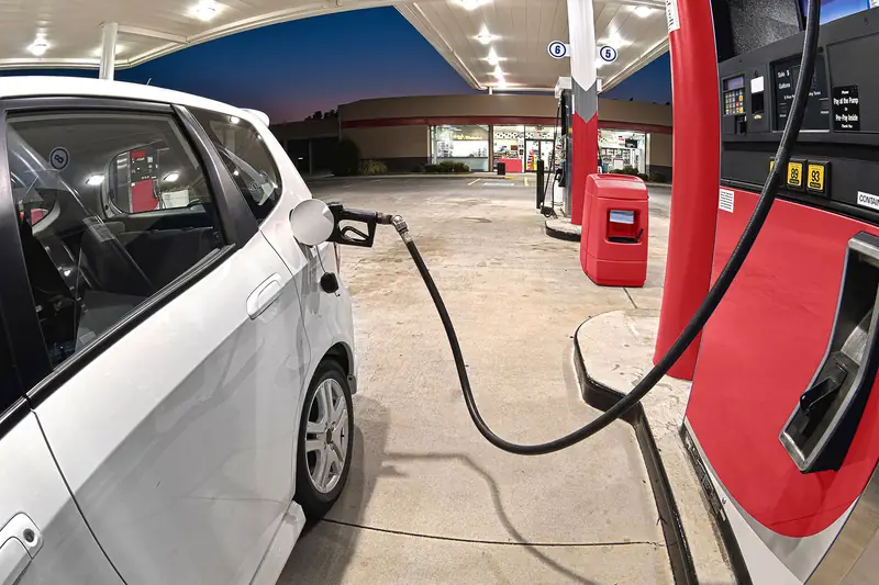 A car at the pump on a station forecourt: fuel and stock bought before they are sold.