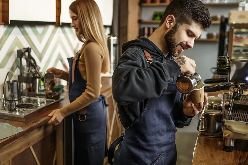 Two baristas at work behind a café counter, where a slow month is short and specific.