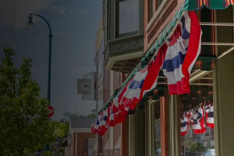 A main-street shop front with bunting over the door: a business with years behind it, planning the next one.